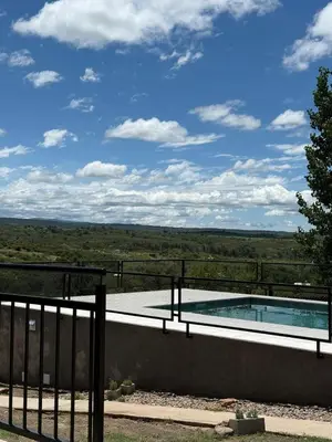 a swimming pool on the side of a house at Cabañas La Caprichosa in Villa Santa Cruz del Lago