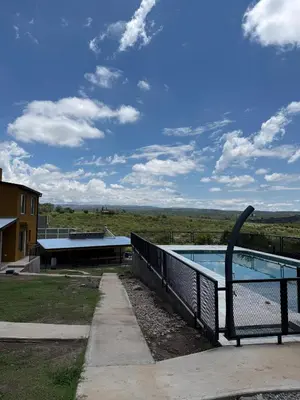 a swimming pool with a fence around it at Cabañas La Caprichosa in Villa Santa Cruz del Lago