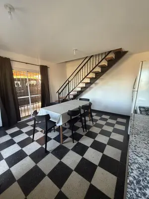 a room with a table and chairs and a staircase at Cabañas La Caprichosa in Villa Santa Cruz del Lago