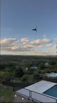 a kite flying in the sky above a building at Cabañas La Caprichosa in Villa Santa Cruz del Lago