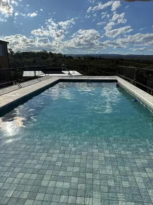 a swimming pool with blue water on top of a house at Cabañas La Caprichosa in Villa Santa Cruz del Lago