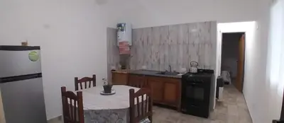 a kitchen with a table and a sink and a stove at Capfer in Alta Gracia