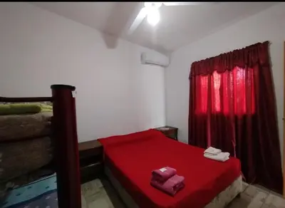a bedroom with a red bed and a red curtain at Capfer in Alta Gracia
