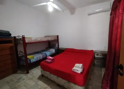 a room with a bed with a red bedspread and a bunk bed at Capfer in Alta Gracia