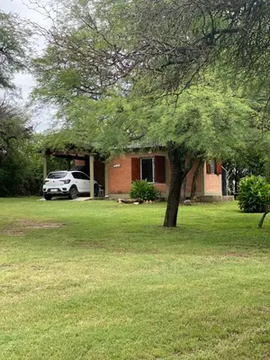 a car parked in front of a house with a tree at Las Luciernagas de Nono in Nono