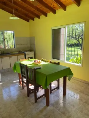 a kitchen with a table with a green table cloth on it at Las Luciernagas de Nono in Nono