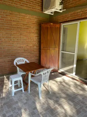 a wooden table and two chairs on a patio at Las Luciernagas de Nono in Nono