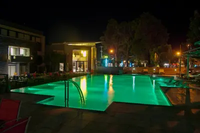 a swimming pool with green lighting at night at Altos De Merlo Suites in Merlo