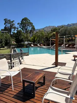 a deck with chairs and a swimming pool at Altos De Merlo Suites in Merlo