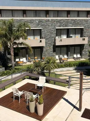 a building with two chairs and a wooden deck at Altos De Merlo Suites in Merlo