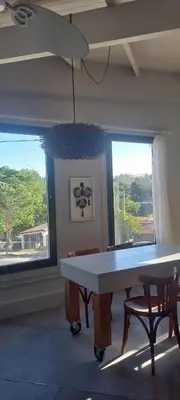 a dining room with a table and two windows at La casa de Merlot in San Antonio de Arredondo