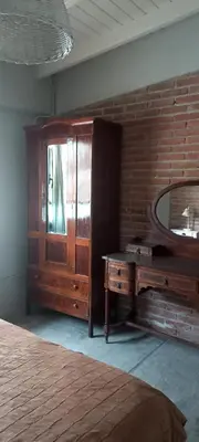 a bedroom with a wooden dresser and a mirror at La casa de Merlot in San Antonio de Arredondo