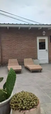 two benches on a patio with a brick wall at La casa de Merlot in San Antonio de Arredondo