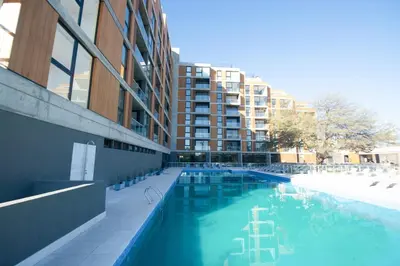 a large swimming pool in front of a building at Relax y diseño frente a la Ciudad Universitaria in Cordoba