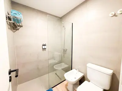 a bathroom with a toilet and a glass shower at Relax y diseño frente a la Ciudad Universitaria in Cordoba