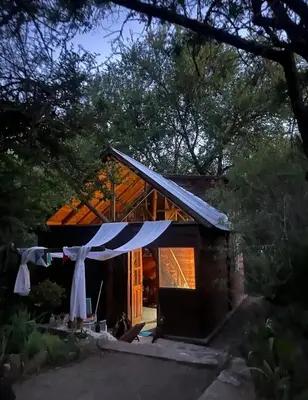 a house with a clothes line in front of it at Cabaña El Poeta in Cuesta Blanca