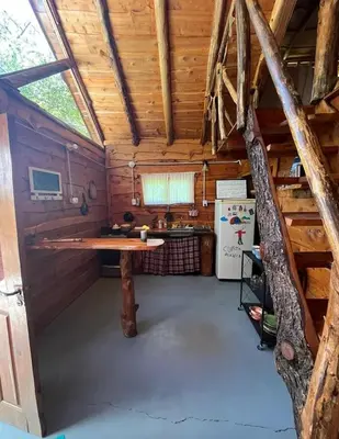 a kitchen with a table in a wooden cabin at Cabaña El Poeta in Cuesta Blanca
