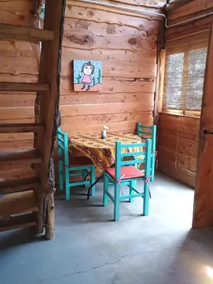a dining room with a table and chairs in a cabin at Cabaña El Poeta in Cuesta Blanca