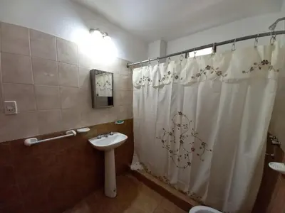 a bathroom with a shower curtain and a sink at Casa Doña Victoria in Villa Carlos Paz