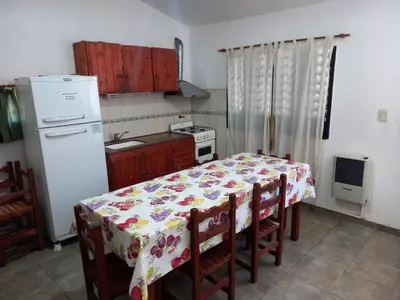 a kitchen with a table with a flowered table cloth at Casa Doña Victoria in Villa Carlos Paz