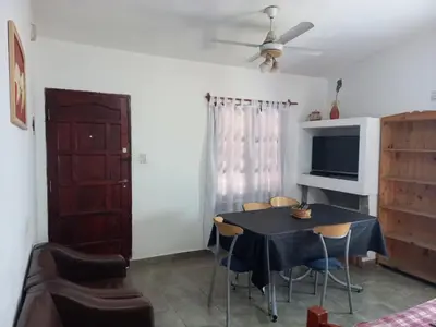 a dining room with a table with chairs and a tv at Casa Doña Victoria in Villa Carlos Paz