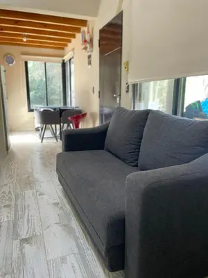 a blue couch in a living room with a table at Wanna Hospedaje in Villa Ciudad Parque