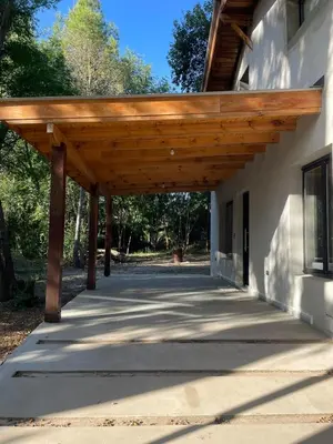 a wooden pergola on the side of a building at Wanna Hospedaje in Villa Ciudad Parque