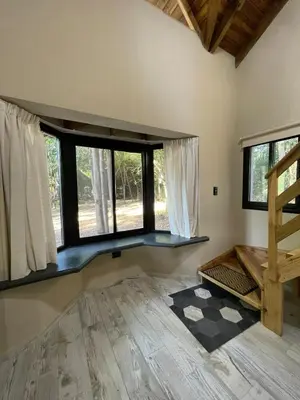 a living room with a large window and a wooden floor at Wanna Hospedaje in Villa Ciudad Parque