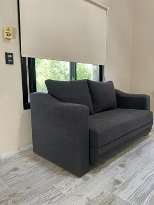 a couch sitting in a living room with a window at Wanna Hospedaje in Villa Ciudad Parque
