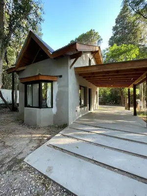 a house with a wooden roof at Wanna Hospedaje in Villa Ciudad Parque