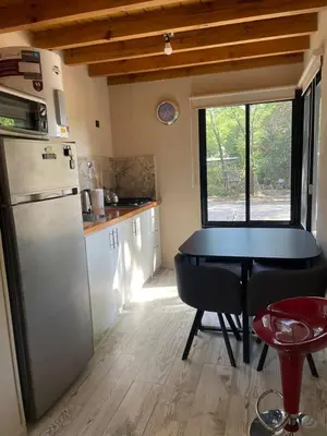 a small kitchen with a table and a refrigerator at Wanna Hospedaje in Villa Ciudad Parque