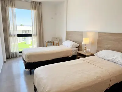 a hotel room with two beds and a window at Edifico NAMBA in Villa Carlos Paz
