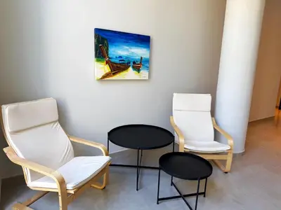 a room with three chairs and a painting on the wall at Edifico NAMBA in Villa Carlos Paz