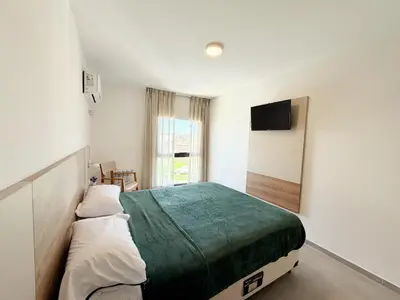 a bedroom with a large bed and a television at Edifico NAMBA in Villa Carlos Paz