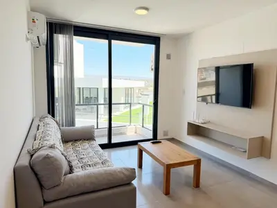 a living room with a couch and a tv and a table at Edifico NAMBA in Villa Carlos Paz