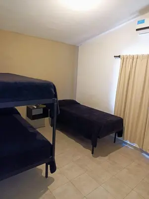 a room with two bunk beds and a curtain at complejo Los Ceibos 2 in Villa Carlos Paz