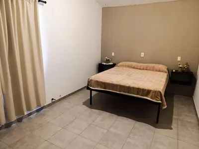 a bedroom with a bed with a blanket on it at complejo Los Ceibos 2 in Villa Carlos Paz