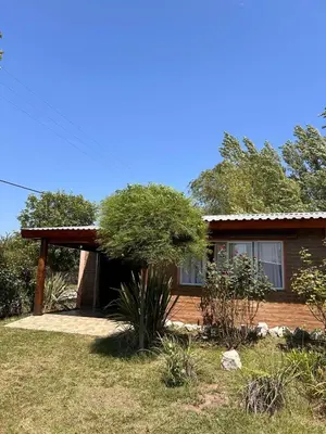 a house with a tree in front of it at Cabañas LOS NAZARENOS - Villa Quillinzo - CALAMUCHITA in Villa Quillinzo