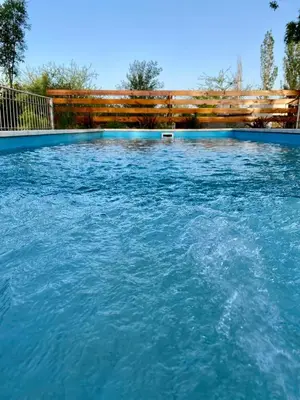 a large swimming pool with blue water at Cabañas LOS NAZARENOS - Villa Quillinzo - CALAMUCHITA in Villa Quillinzo
