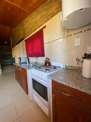 a kitchen with a stove and a counter top at Cabañas LOS NAZARENOS - Villa Quillinzo - CALAMUCHITA in Villa Quillinzo