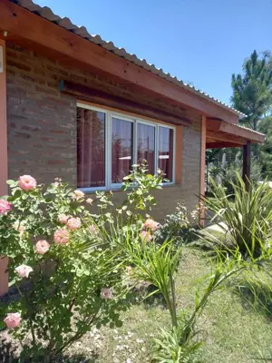 a house with flowers in front of it at Cabañas LOS NAZARENOS - Villa Quillinzo - CALAMUCHITA in Villa Quillinzo