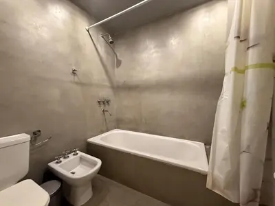 a bathroom with a tub and a toilet and a sink at Moderno Depto 2 dormitorios frente al lago Pileta asador garage in Villa Carlos Paz
