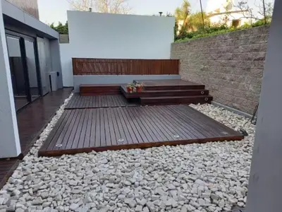 a patio with a bench and a brick wall at Moderno Depto 2 dormitorios frente al lago Pileta asador garage in Villa Carlos Paz