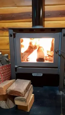 a stove with a fire in a room at Cabaña Don Mario in Villa Yacanto
