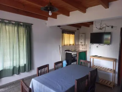a room with a table with chairs and a television at Lo de la Abu in Villa de Las Rosas