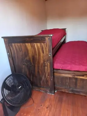 a room with two beds and a fan in it at Lo de la Abu in Villa de Las Rosas