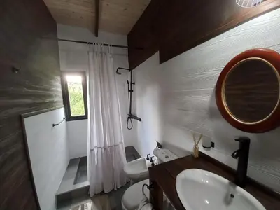 a bathroom with a sink and a toilet and a mirror at Cabaña La Maruca Calamuchita Sierras de Córdoba in San Clemente