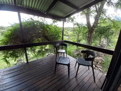 two chairs sitting on a deck with a view at Cabaña La Maruca Calamuchita Sierras de Córdoba in San Clemente