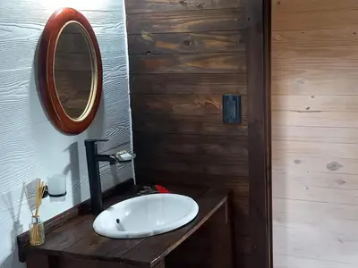 a bathroom with a white sink and a mirror at Cabaña La Maruca Calamuchita Sierras de Córdoba in San Clemente