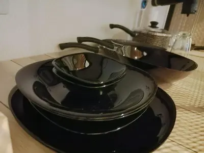 three black plates and bowls on a table at Moderno Departamento para parejas Merlo S Luis centro Vistas in Merlo